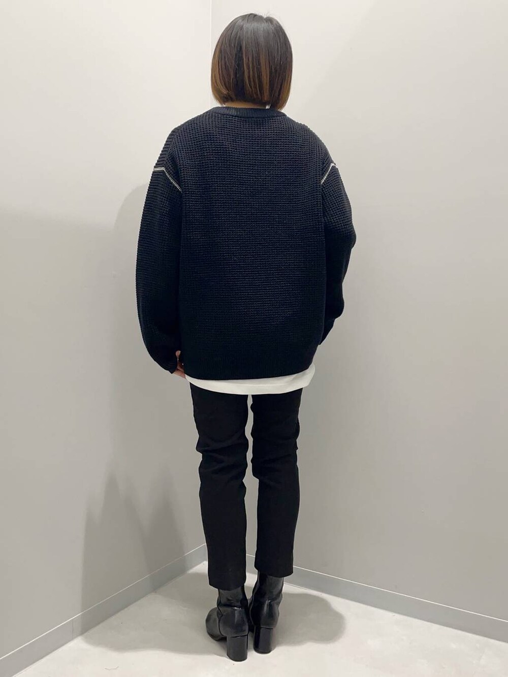 ブラック系のニット/セーター、ホワイト系のTシャツ/カットソー、ブラック系のその他パンツを着用したレディースの秋コーディネートの2枚目の写真