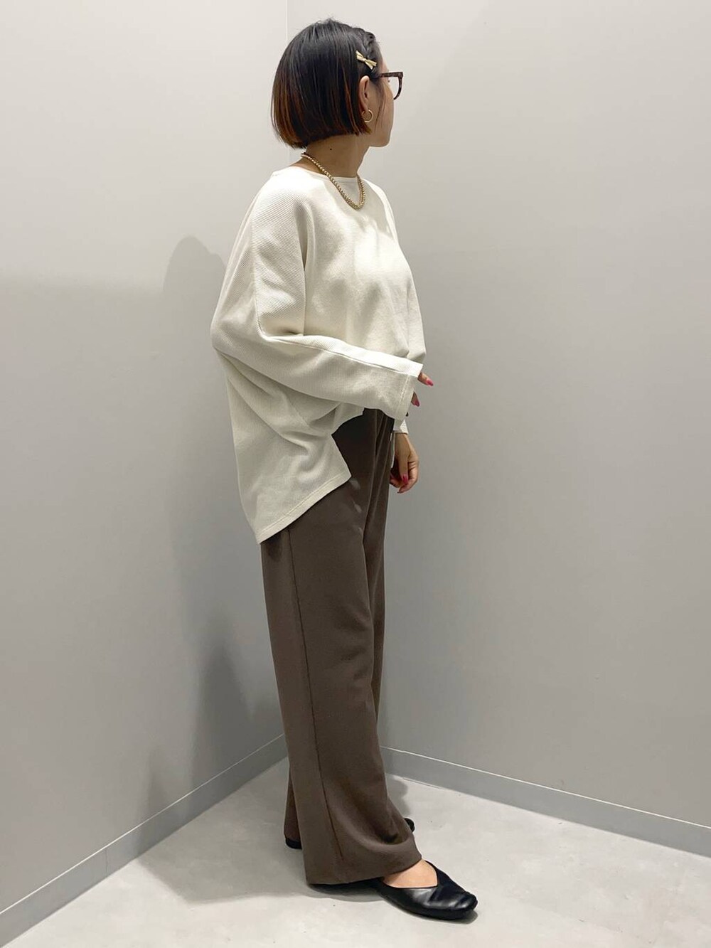 ホワイト系のTシャツ/カットソー、ブラウン系のその他パンツ、イエロー系のネックレスを着用したレディースの秋コーディネートの2枚目の写真