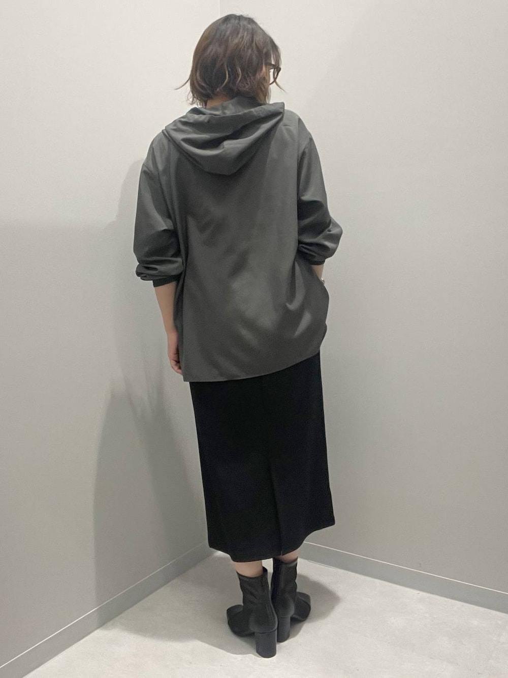 ブラック系のスカート、グレー系のブルゾン、ホワイト系のネックレスを着用したレディースの春コーディネートの3枚目の写真