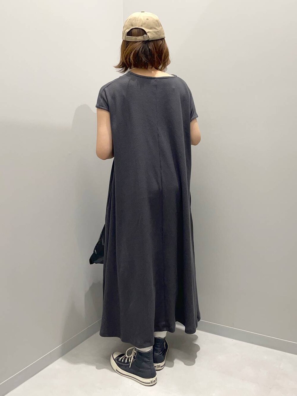 ブラック系のトートバッグ、グレー系のワンピース、ブラウン系のキャップを着用したレディースの夏コーディネートの3枚目の写真