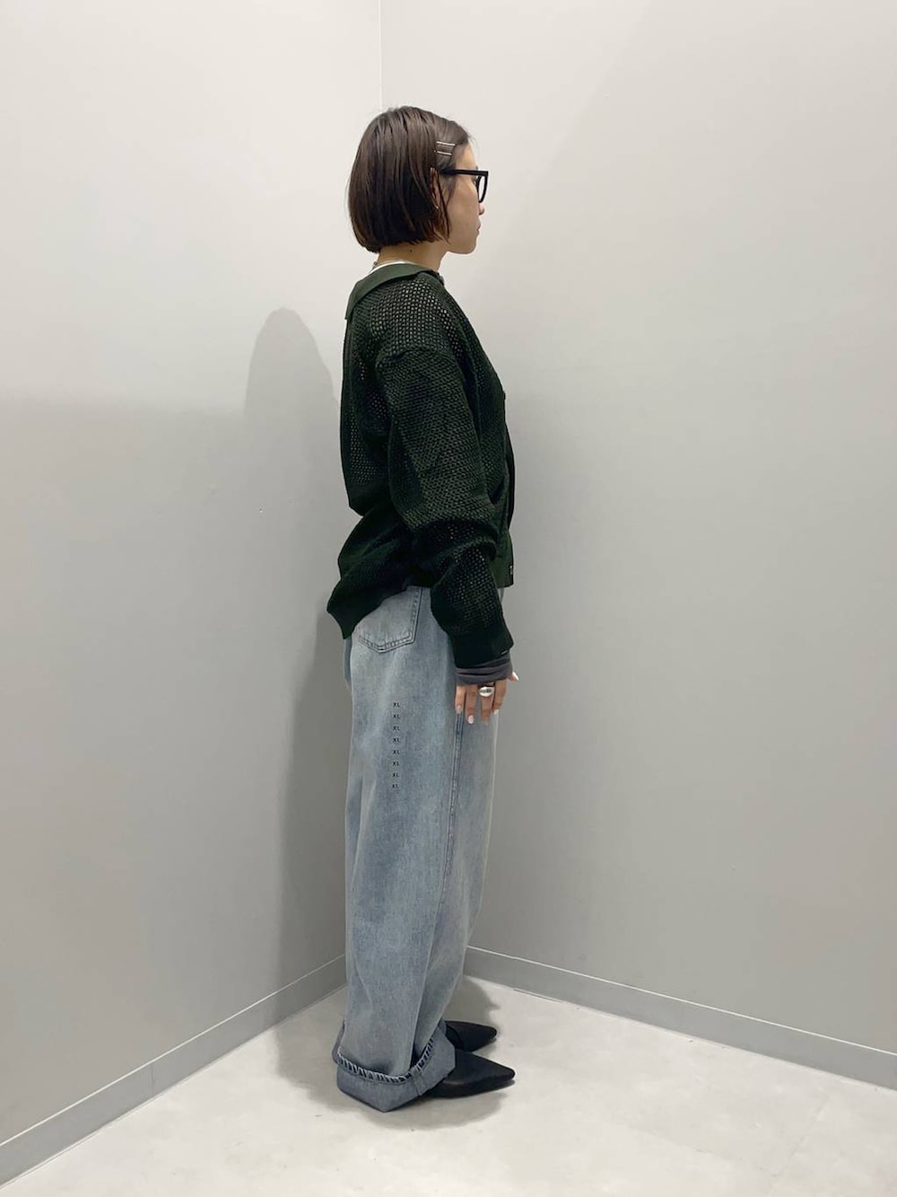 ブルー系のデニムパンツ、ホワイト系のTシャツ/カットソー、グリーン系のカーディガン/ボレロを着用したレディースの春コーディネートの3枚目の写真