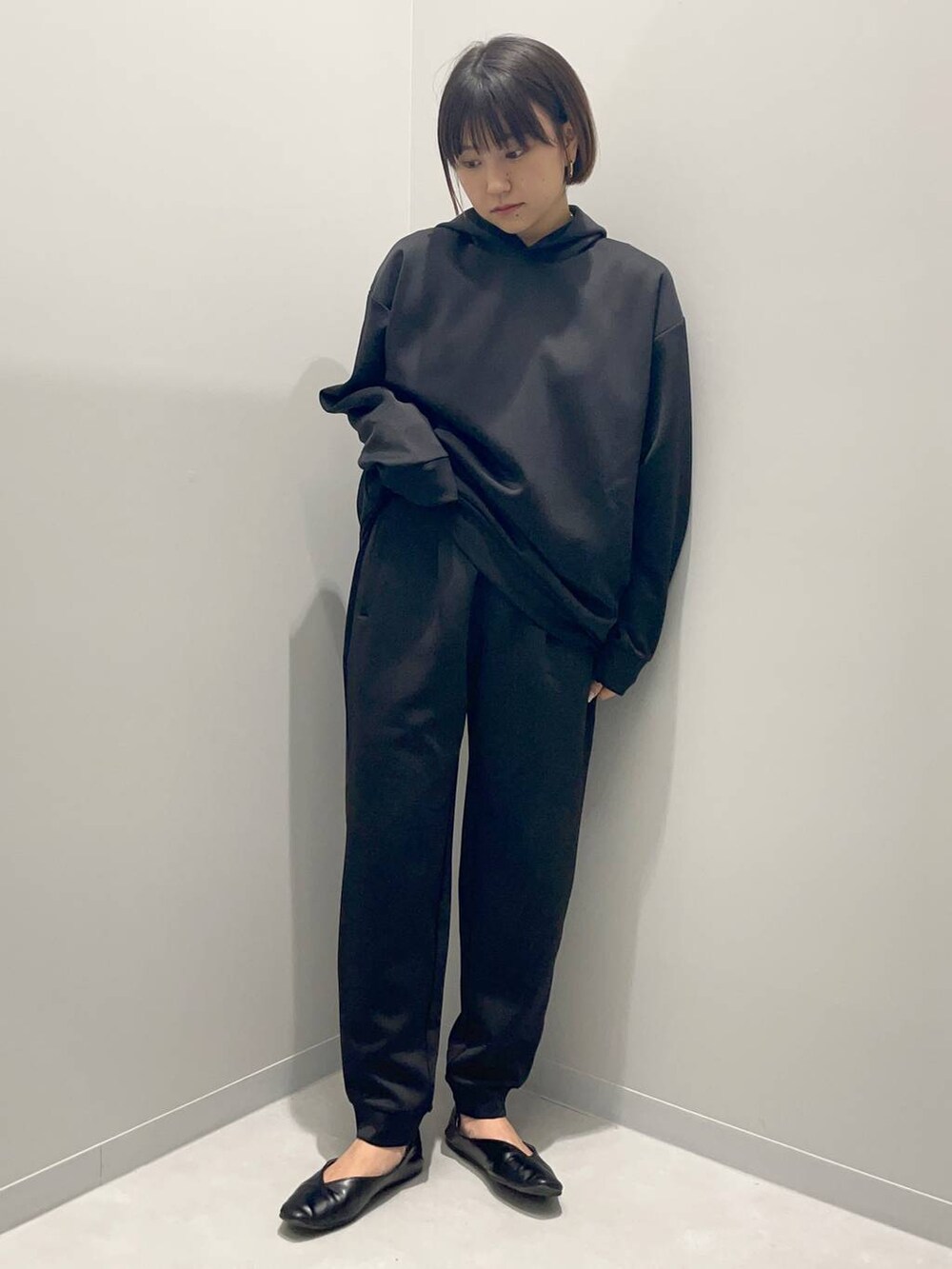 ブラック系のパーカー、ブラック系のスウェットパンツを着用したレディースの秋コーディネートの2枚目の写真