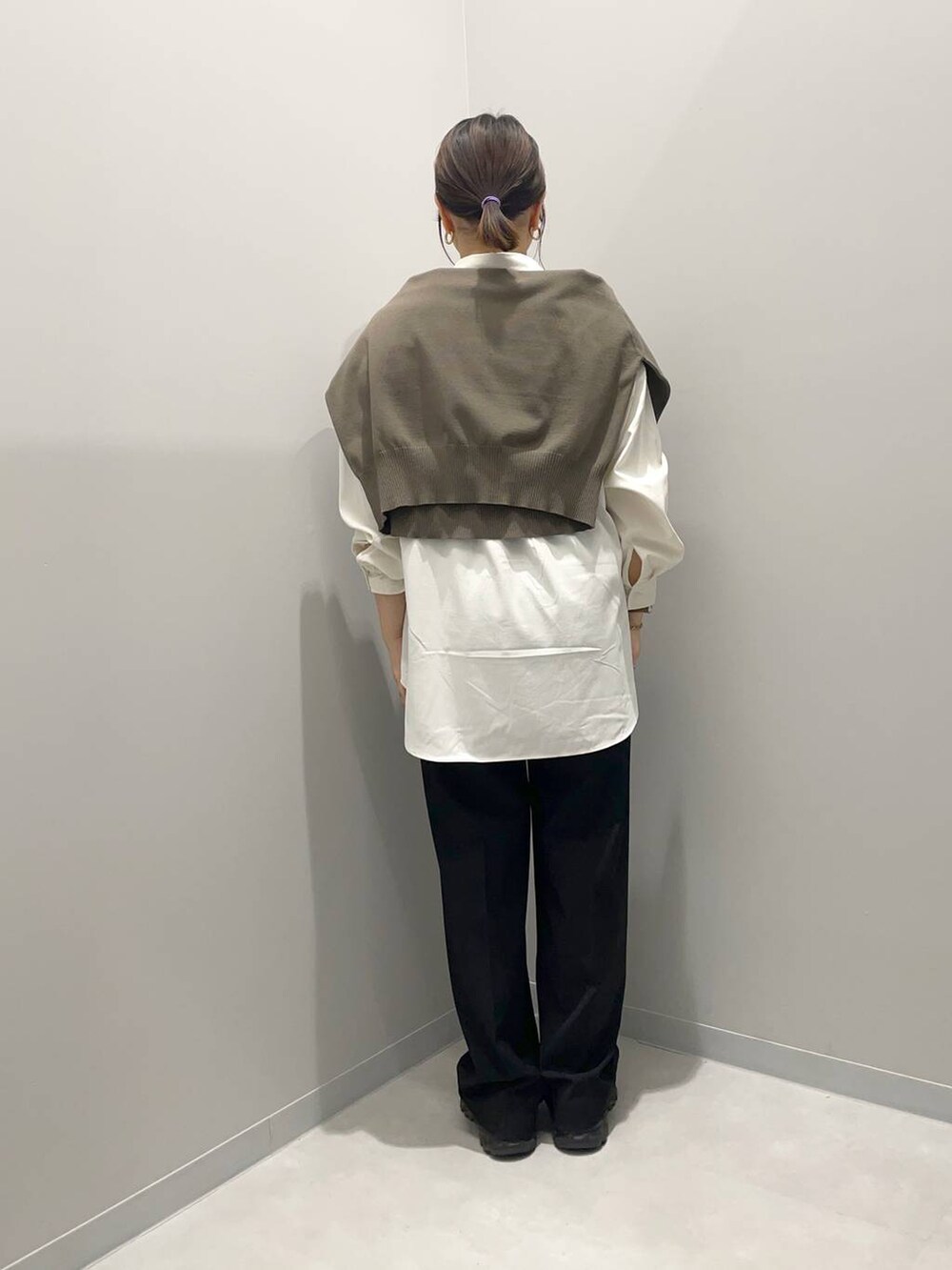 ブラック系のその他パンツ、ブラウン系のニット/セーター、ホワイト系のシャツ/ブラウスを着用したレディースの春コーディネートの5枚目の写真