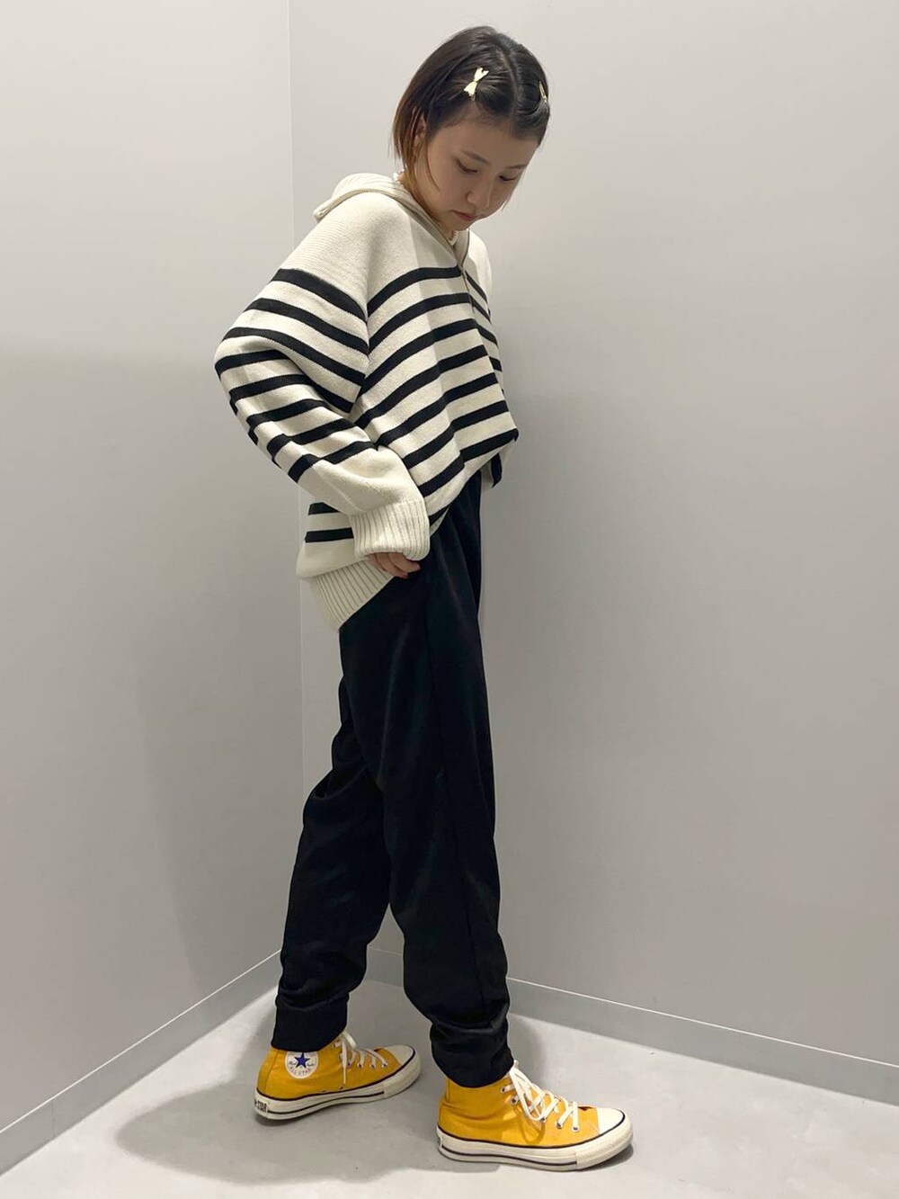 グレー系のニット/セーター、ブラック系のスウェットパンツを着用したレディースの秋コーディネートの4枚目の写真