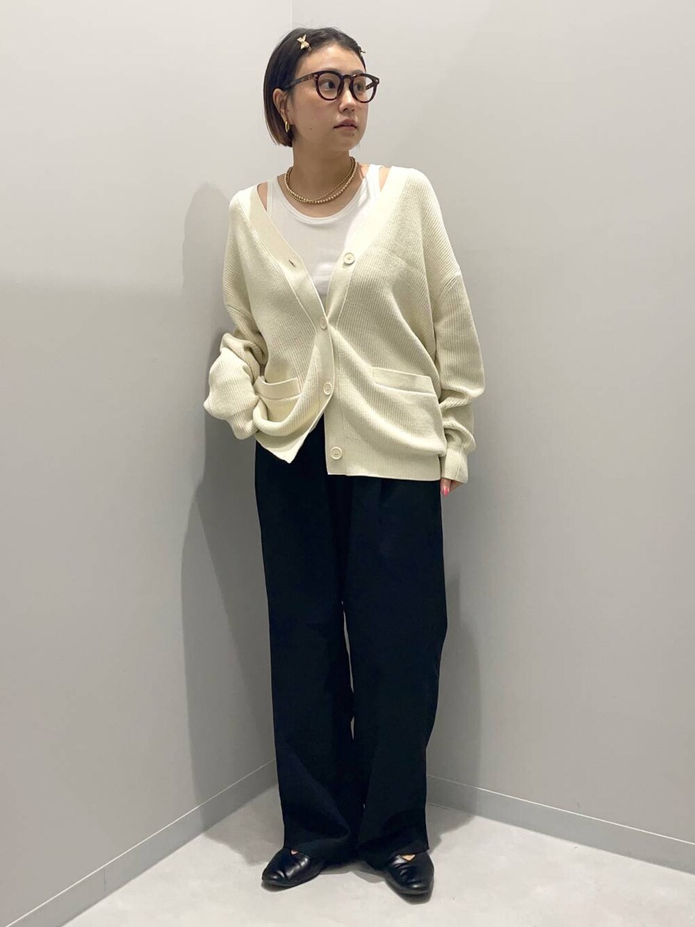 ブラック系のその他パンツ、ホワイト系のニット/セーター、イエロー系のバレッタ/ヘアクリップを着用したレディースの秋コーディネートの2枚目の写真