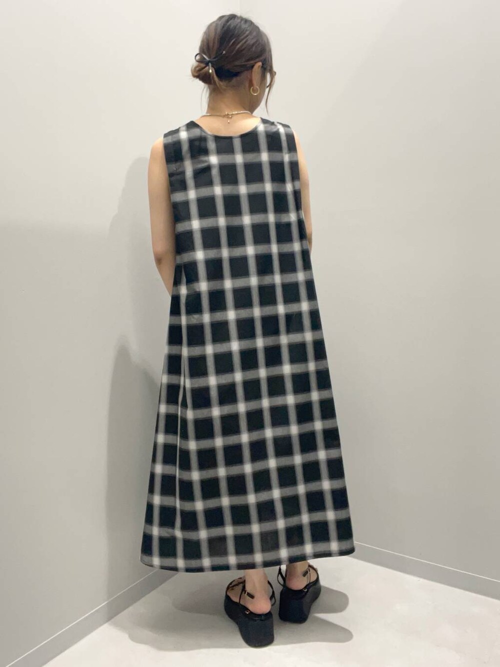 グレー系のワンピース、ホワイト系のネックレスを着用したレディースの夏コーディネートの3枚目の写真