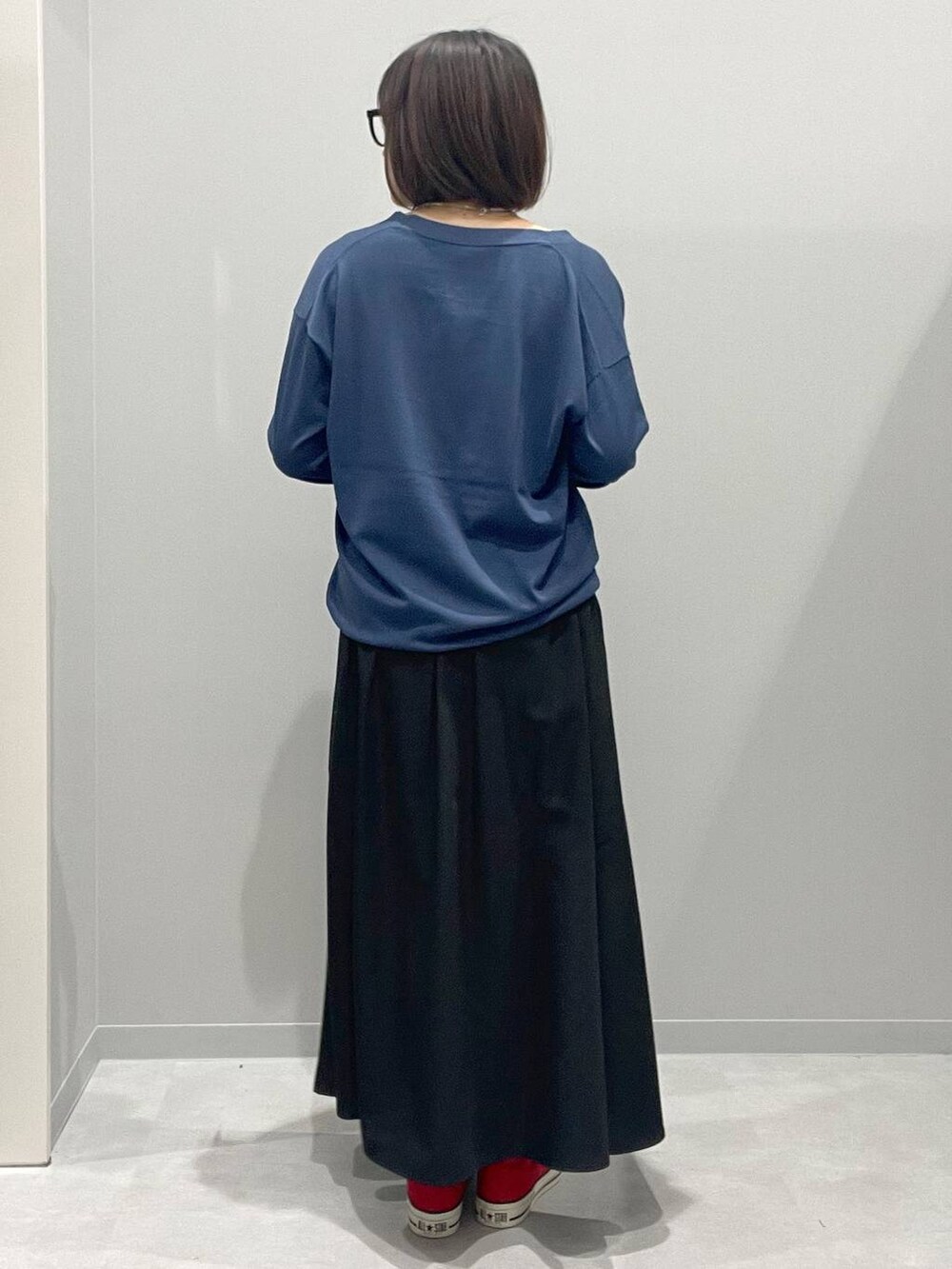 ブラック系のスカート、ブルー系のカーディガン/ボレロ、グレー系のネックレスを着用したレディースの春コーディネートの3枚目の写真
