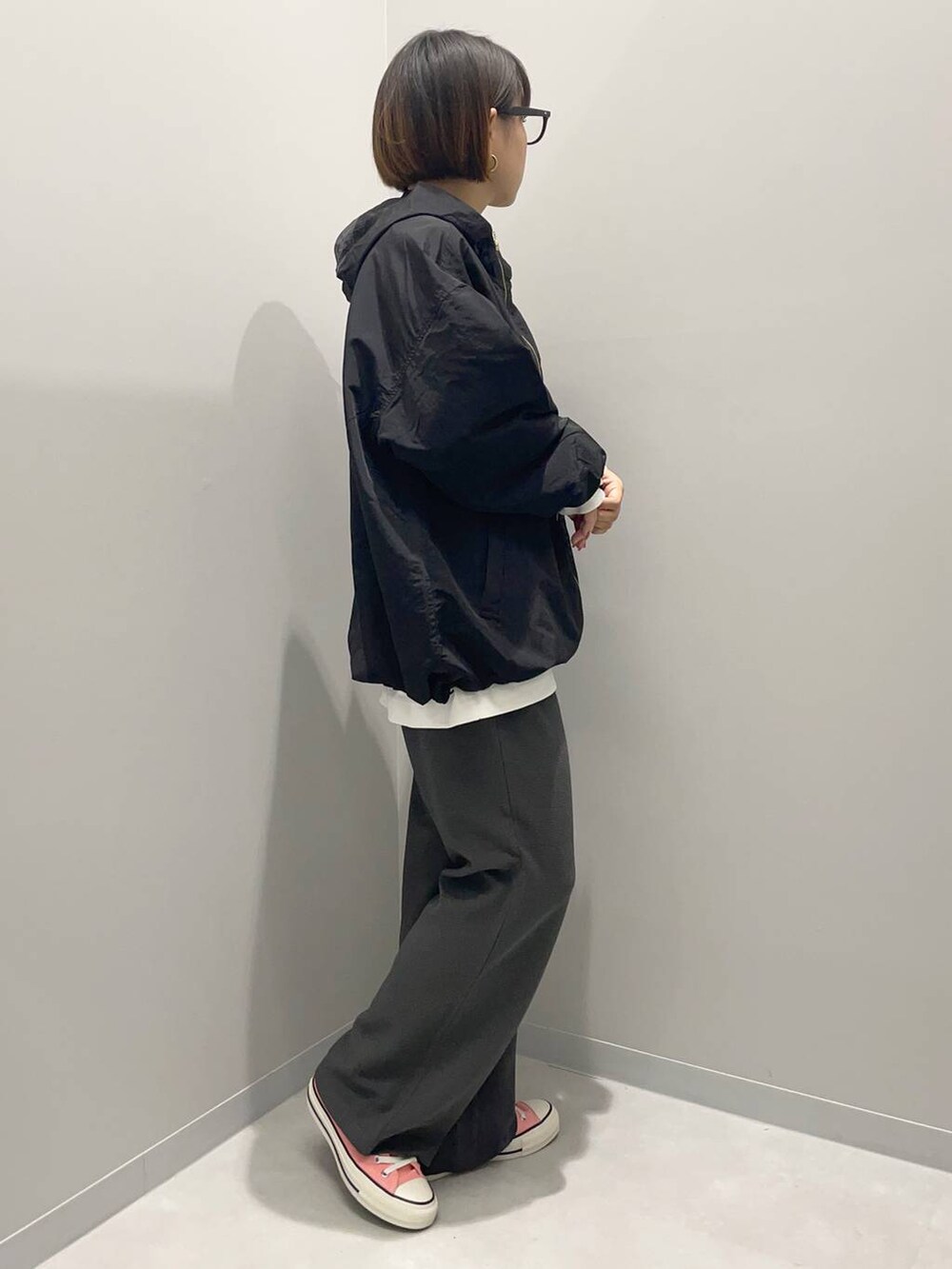 ホワイト系のTシャツ/カットソー、ブラック系のブルゾン、グレー系のその他パンツを着用したレディースの秋コーディネートの2枚目の写真