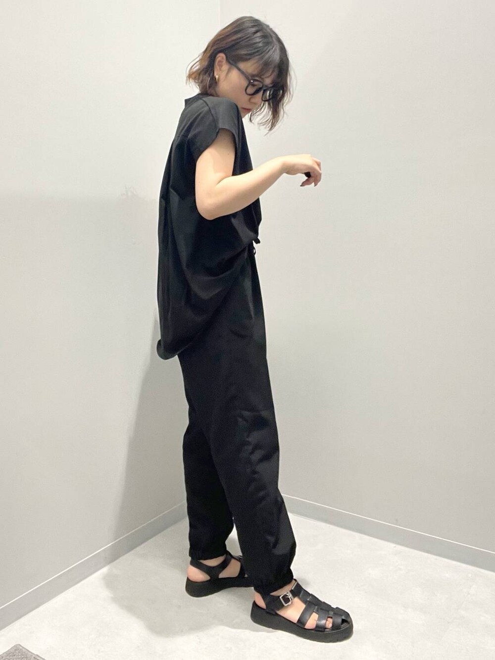 ブラック系のTシャツ/カットソー、ブラック系のその他パンツ、ホワイト系のネックレスを着用したレディースの春コーディネートの2枚目の写真