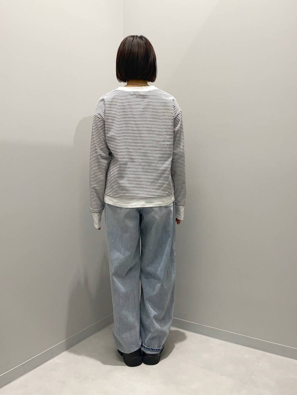 ブルー系のデニムパンツ、ブラウン系のショルダーバッグ、その他のTシャツ/カットソーを着用したレディースの春コーディネートの4枚目の写真