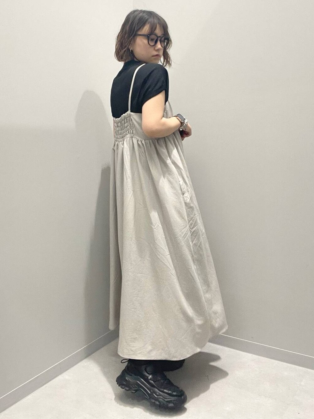 グレー系のワンピース、ブラック系のニット/セーター、ブラック系のソックス/靴下を着用したレディースの春コーディネートの2枚目の写真