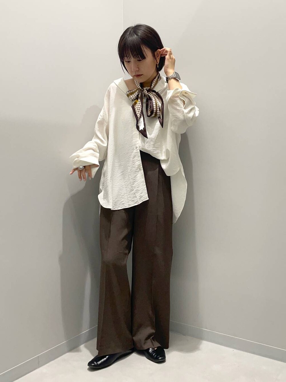 ブラウン系のスラックス、ホワイト系のシャツ/ブラウス、ベージュ系のその他ヘアアクセサリーを着用したレディースの夏コーディネートの2枚目の写真