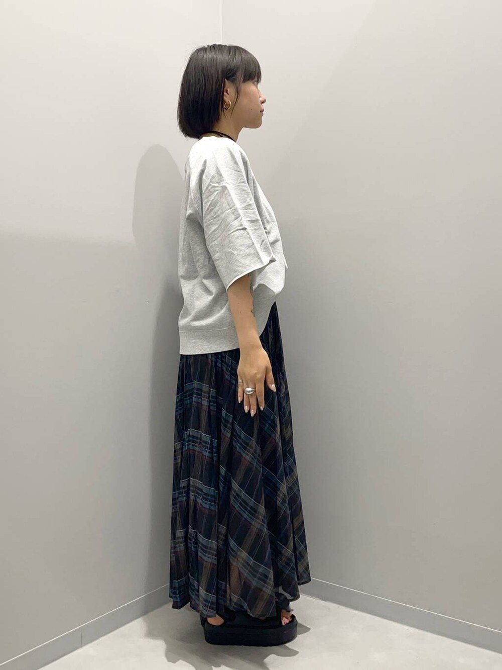 ブラック系のスカート、ゴールド系のチョーカーを着用したレディースの夏コーディネートの3枚目の写真