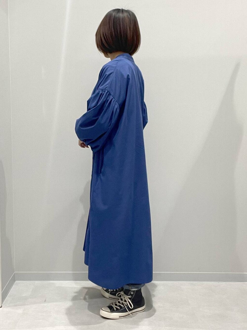 ホワイト系のTシャツ/カットソー、ブルー系のシャツワンピース、ブルー系のデニムパンツを着用したレディースの春コーディネートの2枚目の写真