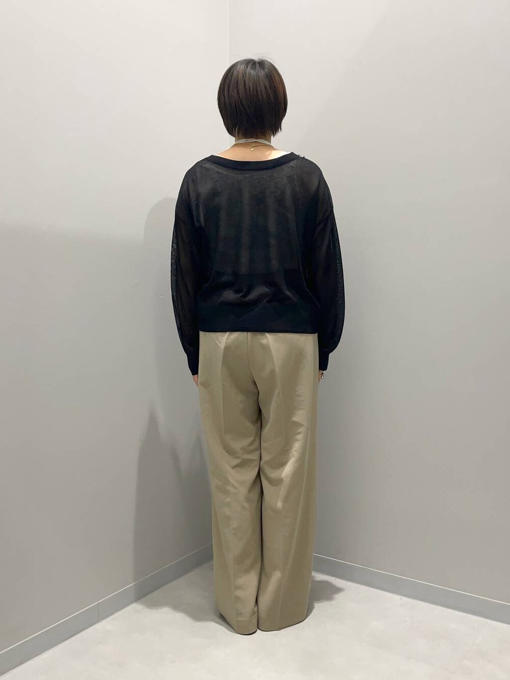 ベージュ系のその他パンツ、ブラック系のパンプス、ホワイト系のネックレスを着用したレディースの春コーディネートの4枚目の写真