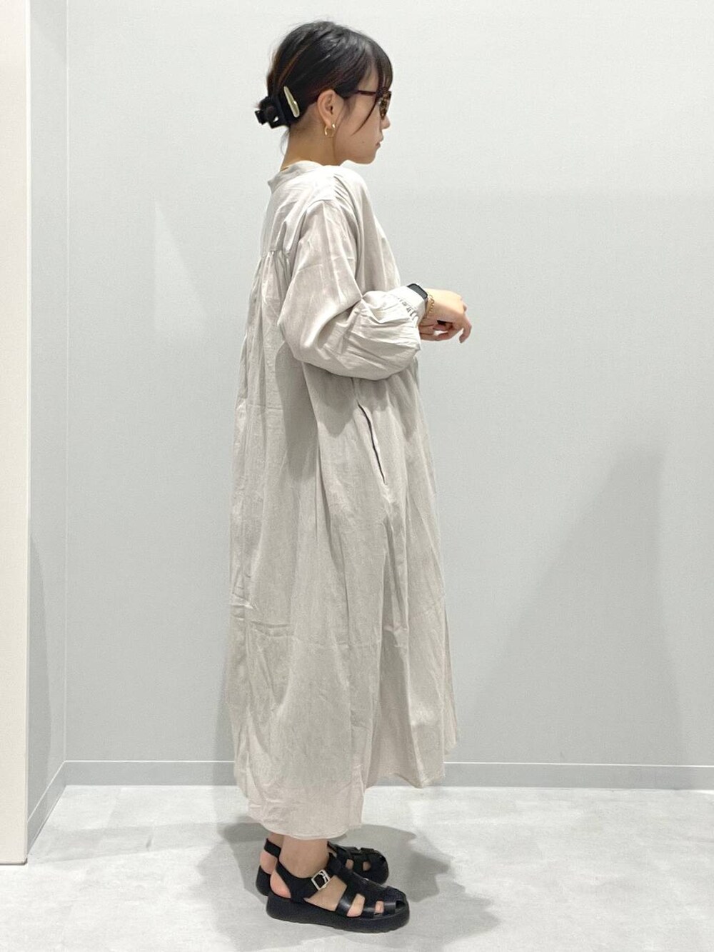 ベージュ系のシャツワンピース、ホワイト系のネックレスを着用したレディースの春コーディネートの2枚目の写真