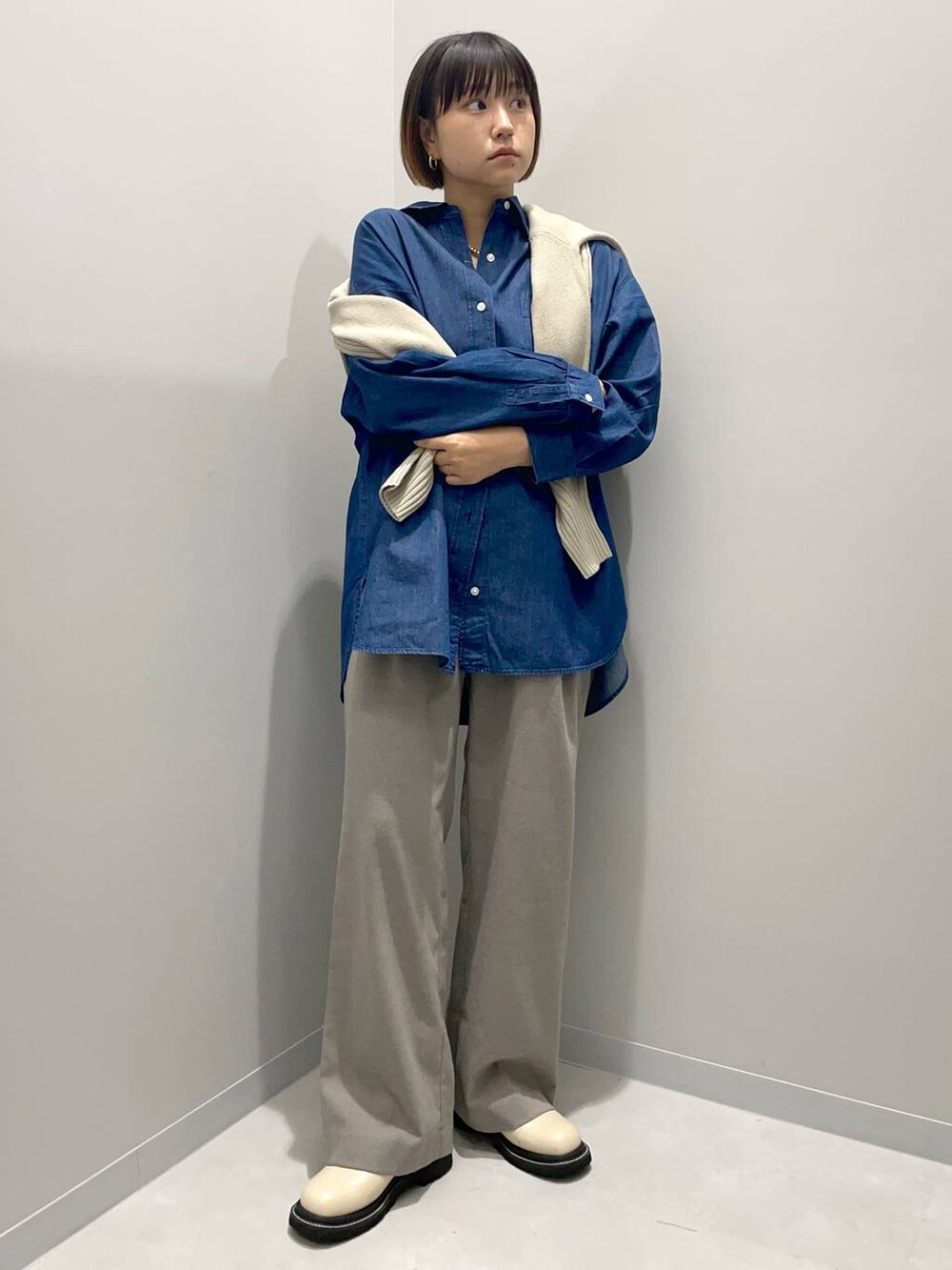 ブラウン系のその他パンツ、ブルー系のシャツ/ブラウス、ベージュ系のニット/セーターを着用したレディースの秋コーディネートの2枚目の写真