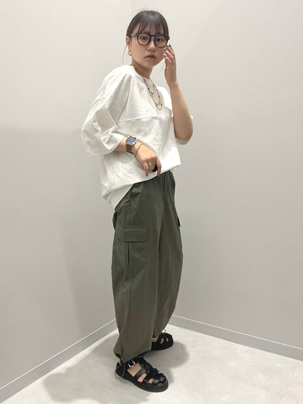 グリーン系のカーゴパンツ、ホワイト系のTシャツ/カットソー、オレンジ系のネックレスを着用したレディースの春コーディネートの2枚目の写真