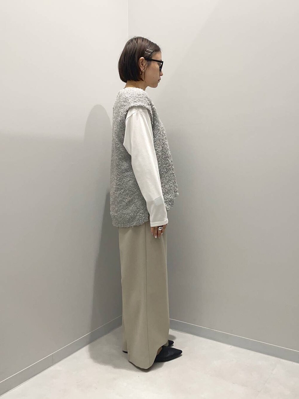 ブラウン系のショルダーバッグ、ベージュ系のその他パンツ、グレー系のベストを着用したレディースの春コーディネートの3枚目の写真