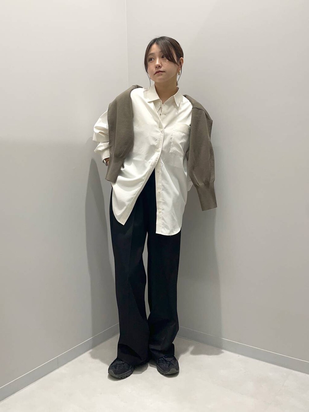 ブラック系のその他パンツ、ブラウン系のニット/セーター、ホワイト系のシャツ/ブラウスを着用したレディースの春コーディネートの2枚目の写真