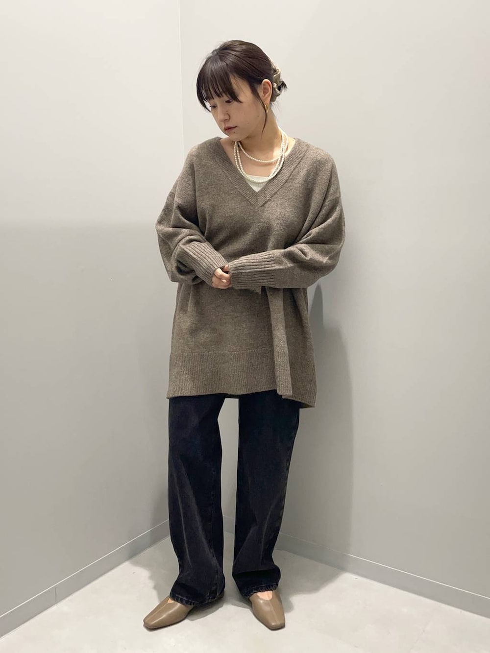 ブラック系のデニムパンツを着用したレディースの秋コーディネートの2枚目の写真