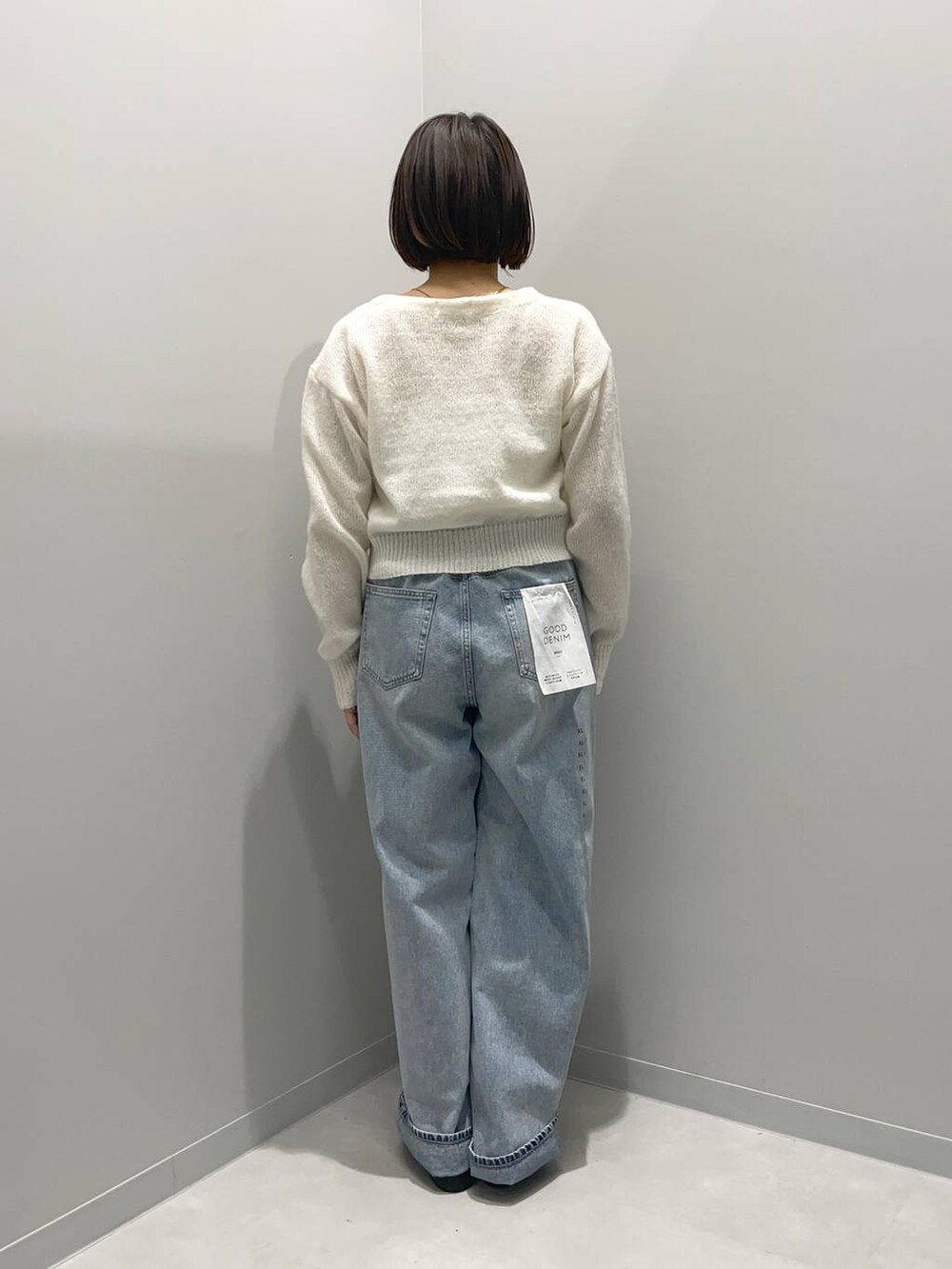 ブルー系のデニムパンツ、ホワイト系のカーディガン/ボレロを着用したレディースの春コーディネートの4枚目の写真