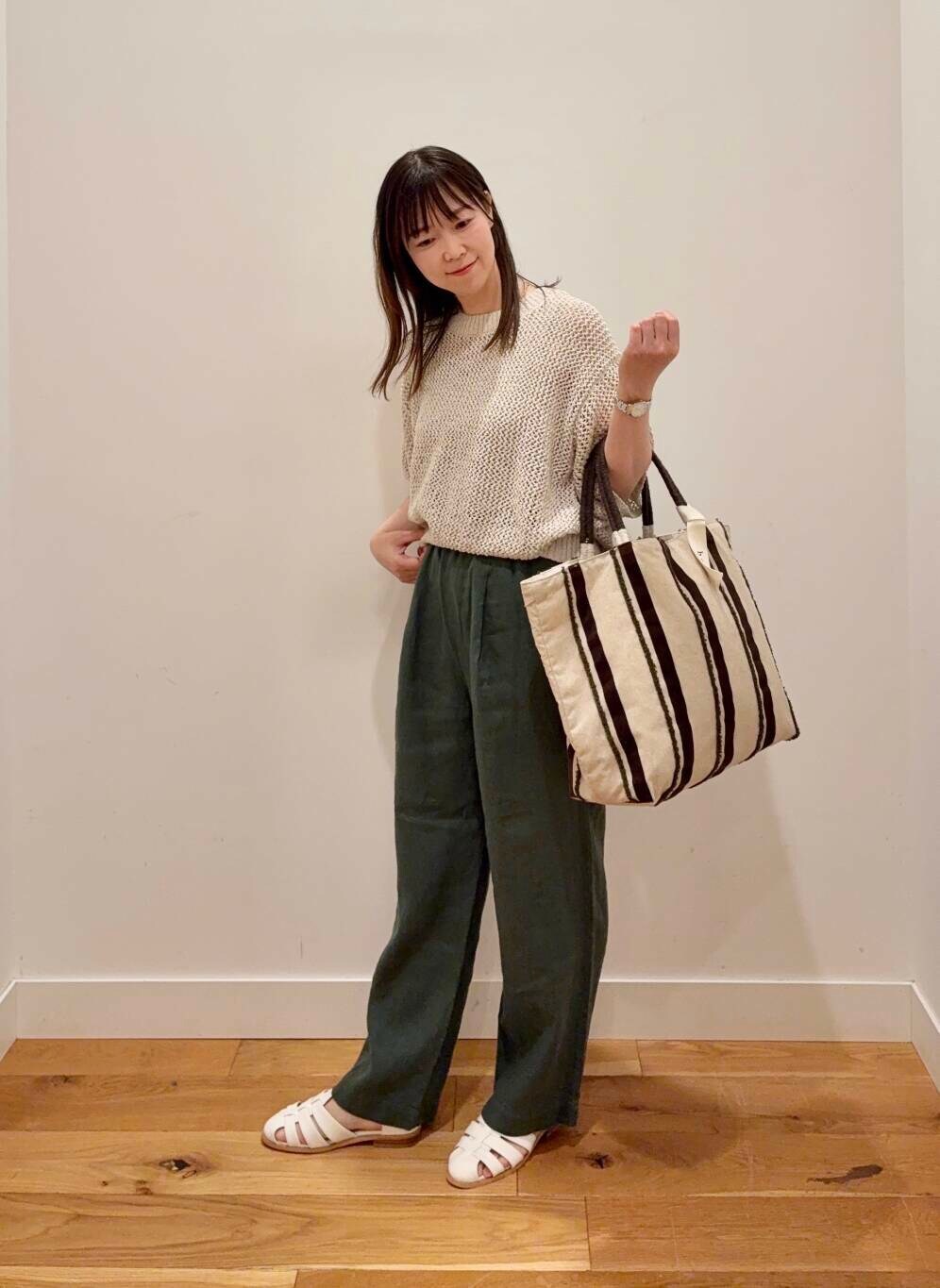 グリーン系のその他パンツ、ホワイト系のサンダル、ベージュ系のタンクトップを着用したレディースの春コーディネートの4枚目の写真