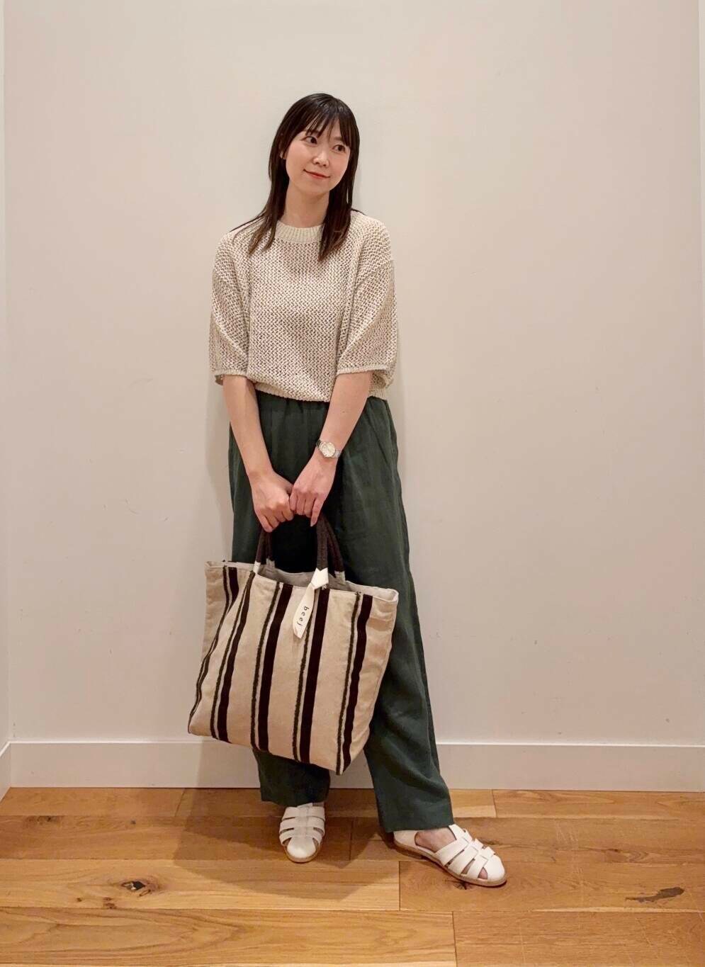 グリーン系のその他パンツ、ホワイト系のサンダル、ベージュ系のタンクトップを着用したレディースの春コーディネートの2枚目の写真