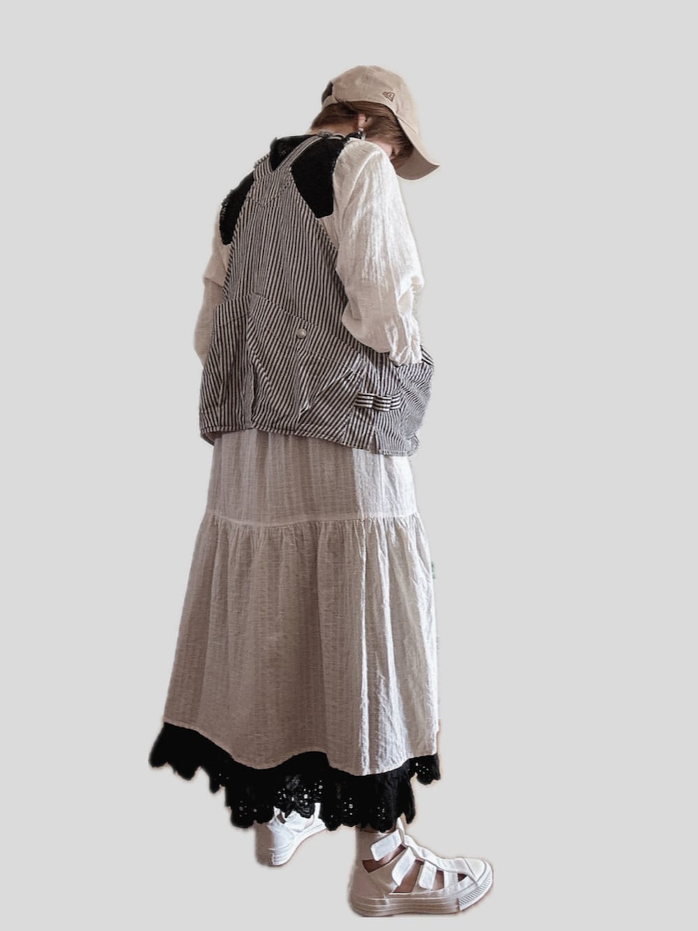 ホワイト系のワンピース、その他のベスト、ホワイト系のスニーカーを着用したレディースの春コーディネートの2枚目の写真