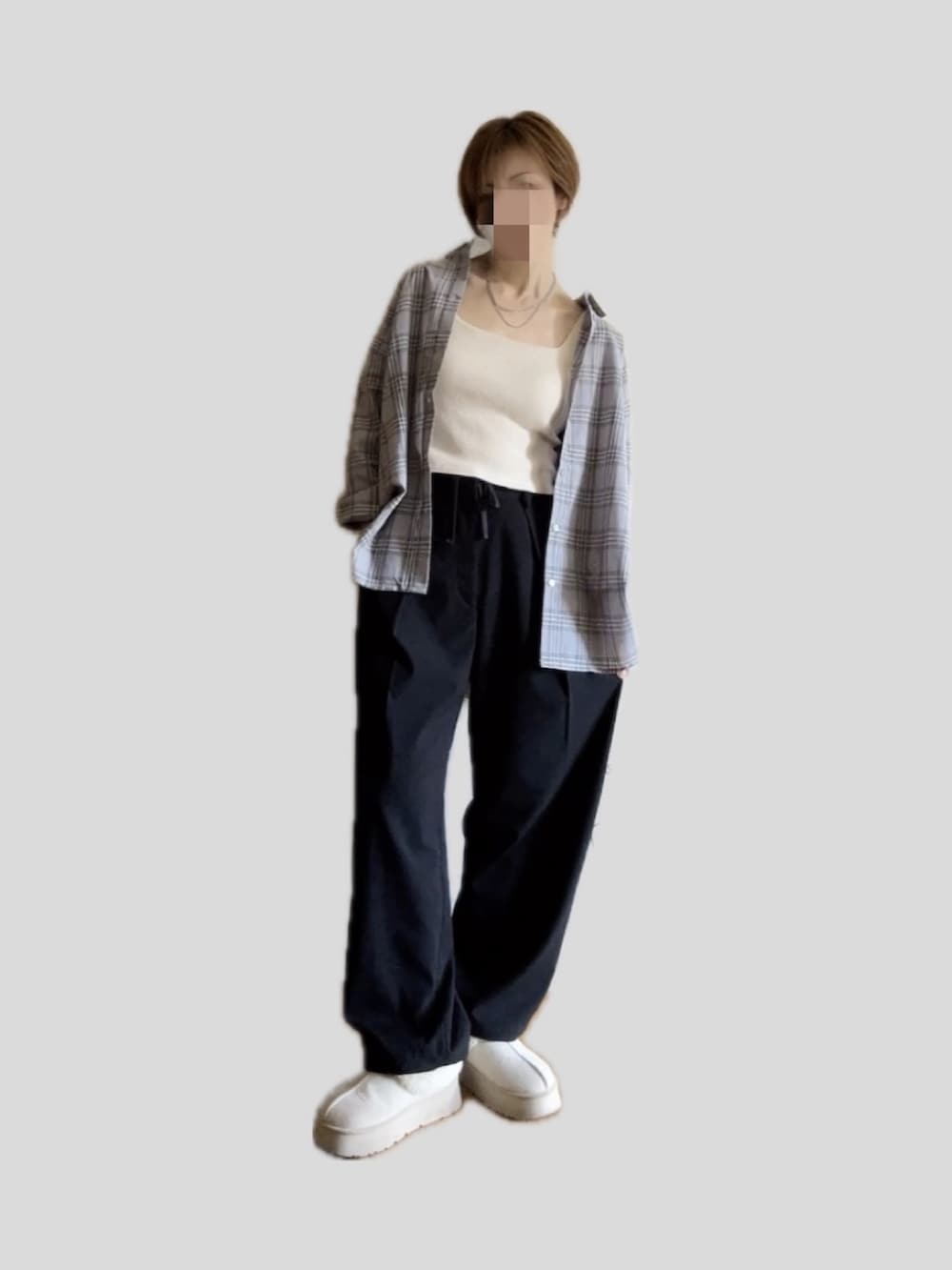 ブラック系のスラックス、ホワイト系のブーツ、グレー系のシャツ/ブラウスを着用したレディースの秋コーディネートの3枚目の写真