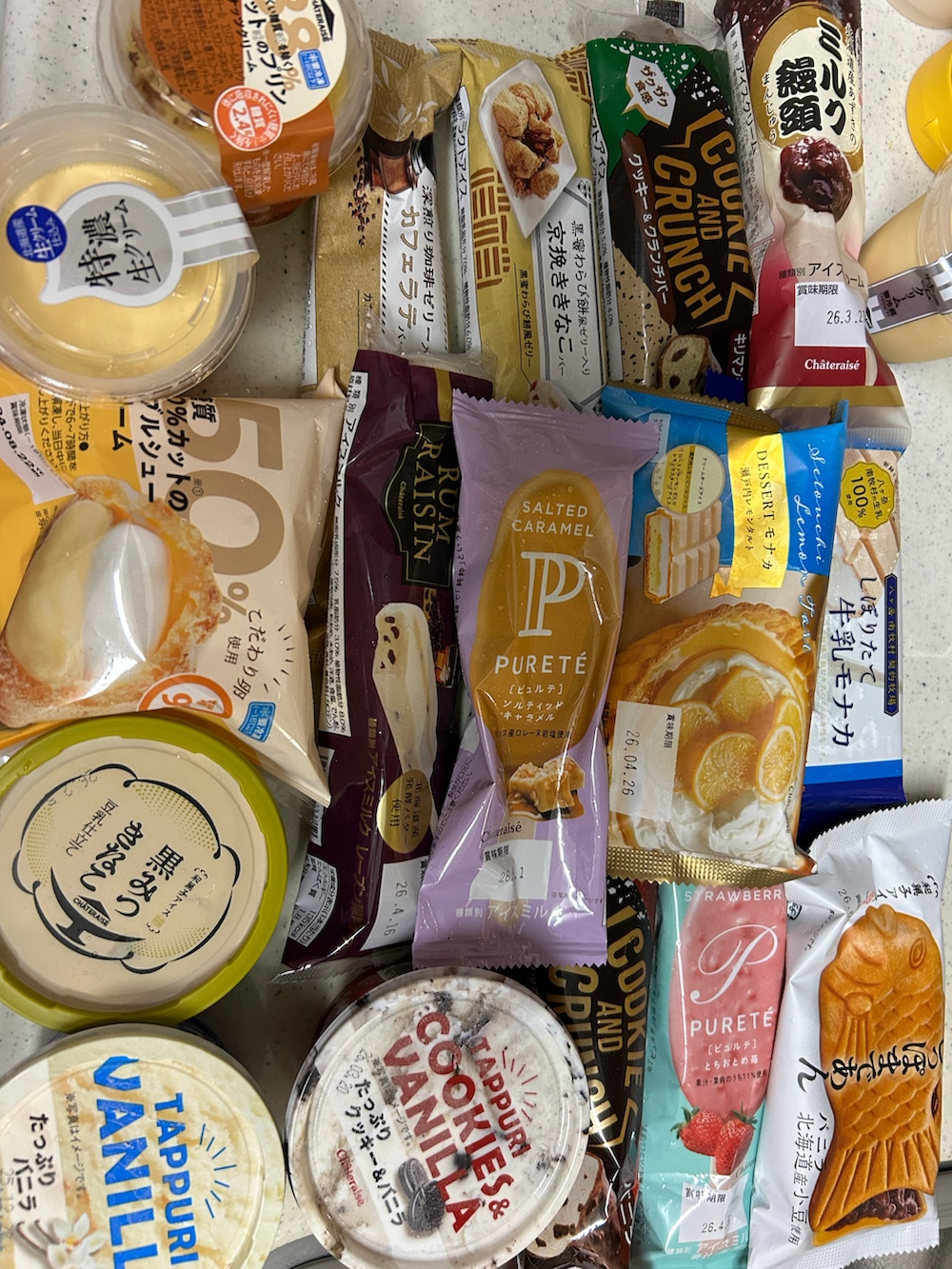 イエロー系のトートバッグ、ブルー系のジャンパースカート、ホワイト系のTシャツ/カットソーを着用したレディースの春コーディネートの2枚目の写真