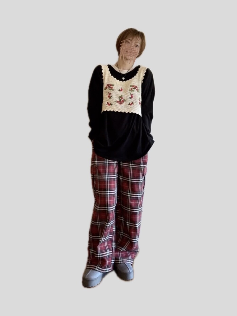 レッド系のカーゴパンツ、ホワイト系のベスト、グレー系のブーツを着用したレディースの秋コーディネートの3枚目の写真