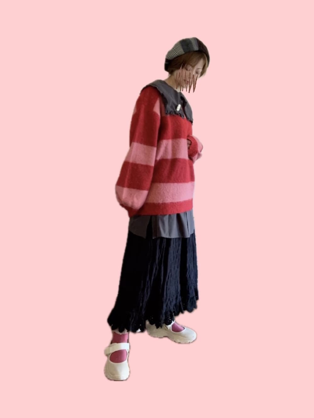 レッド系のニット/セーター、ブラック系のスカート、ベージュ系のスニーカーを着用したレディースの冬コーディネートの3枚目の写真