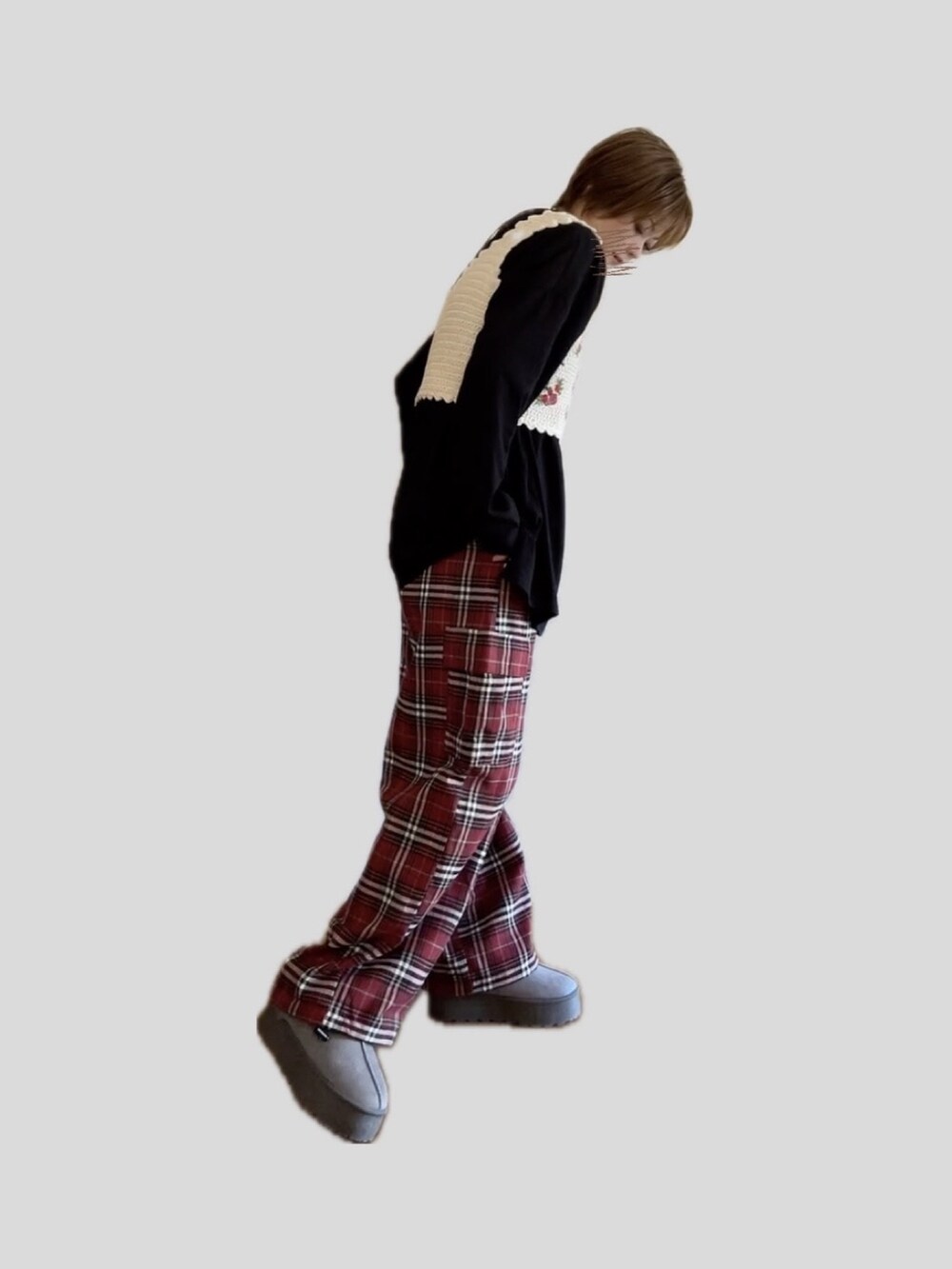 レッド系のカーゴパンツ、ホワイト系のベスト、グレー系のブーツを着用したレディースの秋コーディネートの2枚目の写真