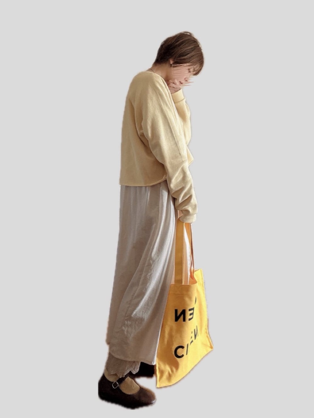 イエロー系のスウェット、イエロー系のトートバッグ、ブラウン系のバレエシューズを着用したレディースの春コーディネートの2枚目の写真