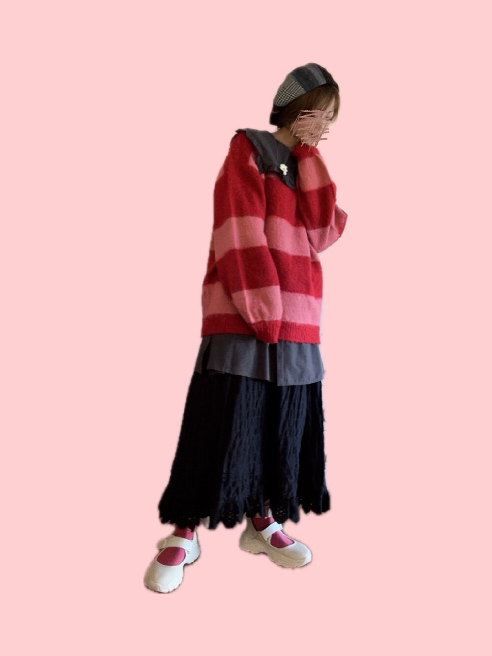 レッド系のニット/セーター、ブラック系のスカート、ベージュ系のスニーカーを着用したレディースの冬コーディネートの2枚目の写真