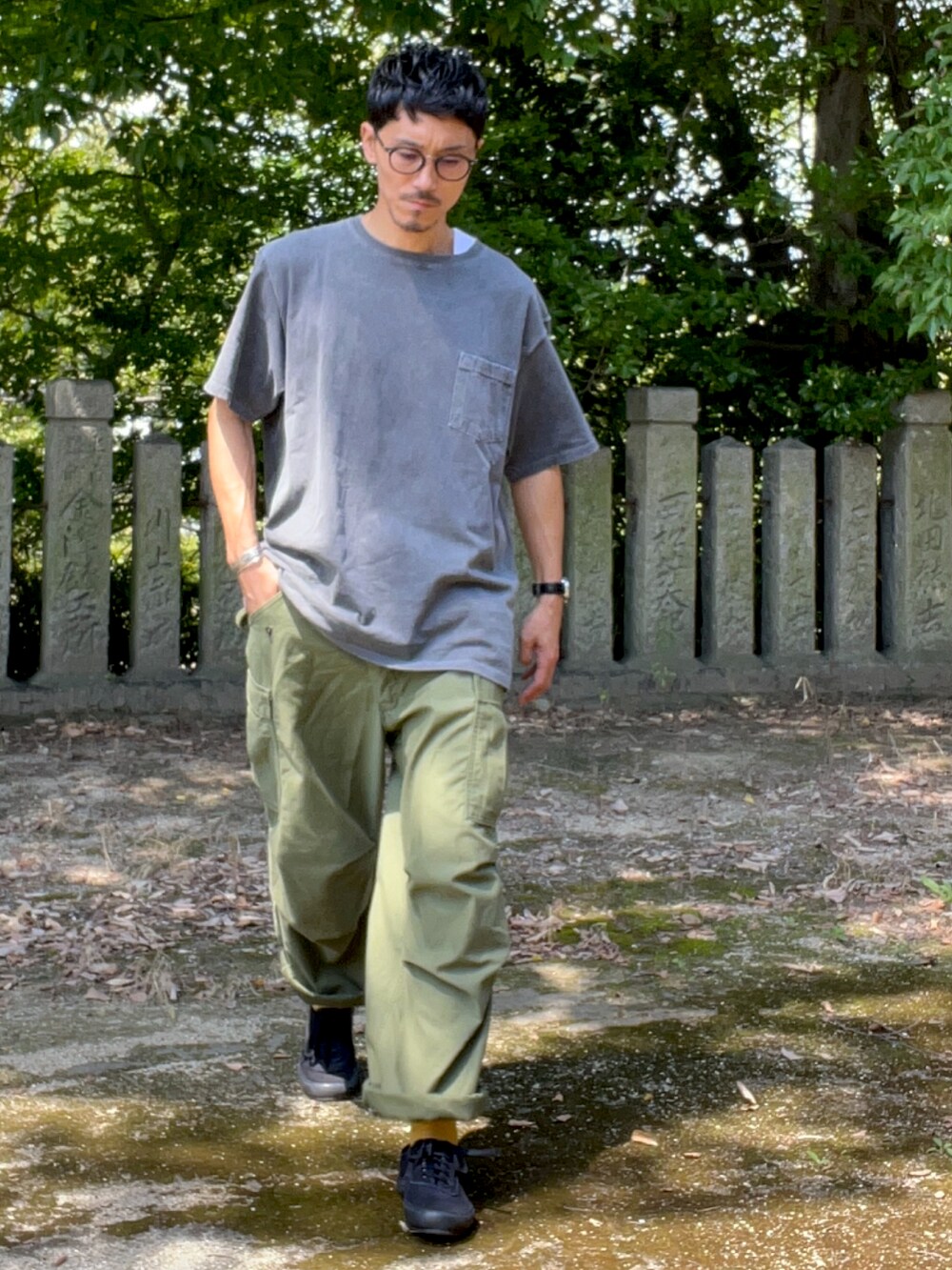 パープル系のTシャツ/カットソー、グリーン系のカーゴパンツ、ブラック系のスニーカーを着用したメンズの秋コーディネートの2枚目の写真