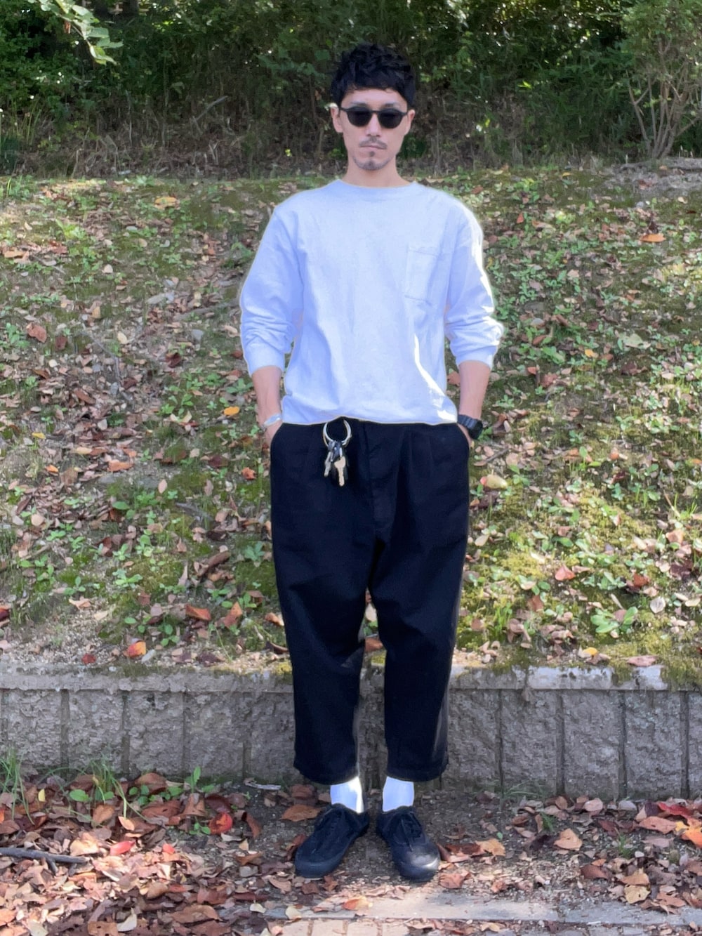 ブラック系のチノパンツ、ブラック系のスニーカー、ホワイト系のTシャツ/カットソーを着用したメンズの秋コーディネートの2枚目の写真