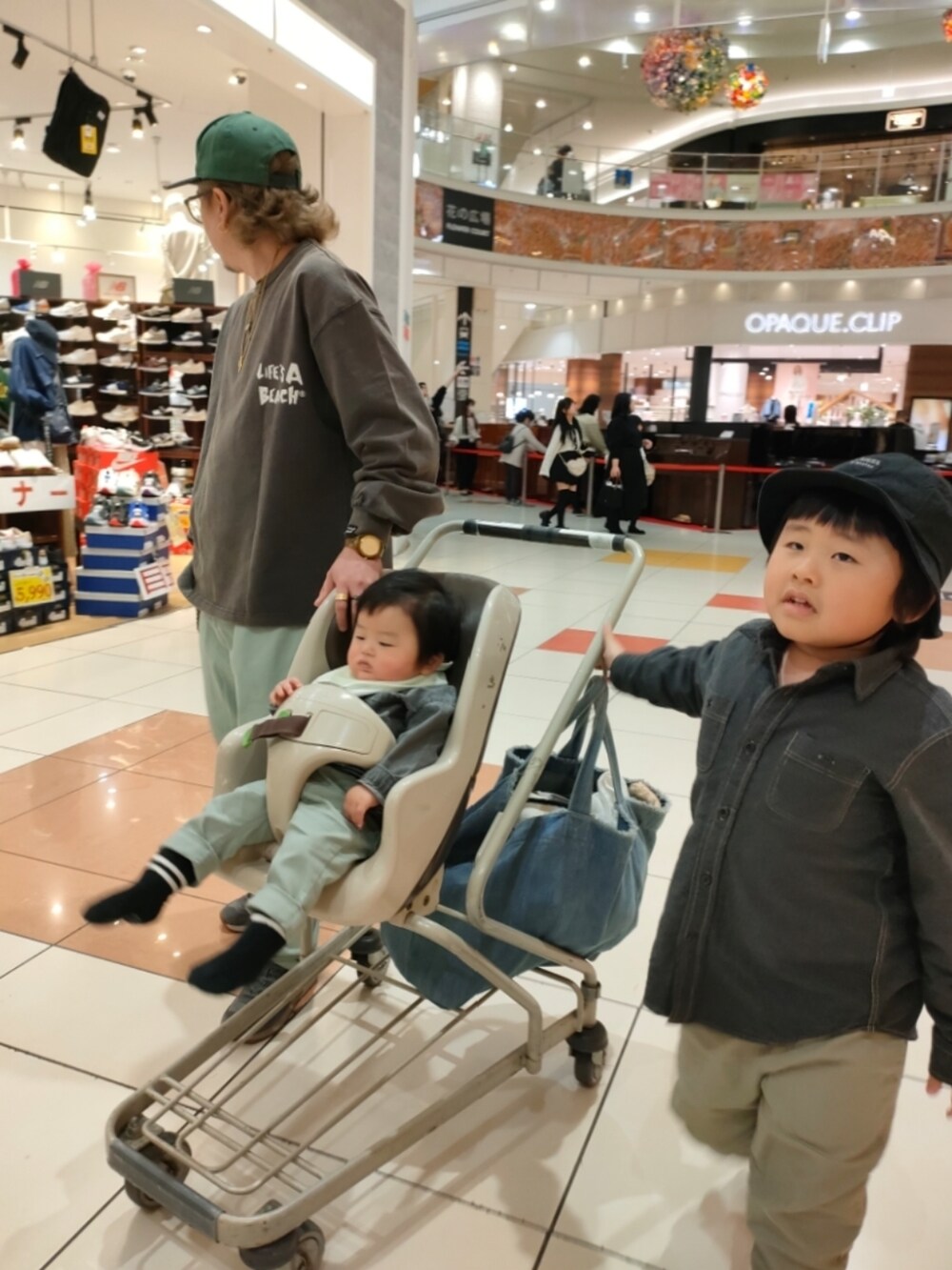 グリーン系のパンツ、ブラック系のスニーカー、グレー系のシャツ/ブラウスを着用したキッズの春コーディネートの3枚目の写真