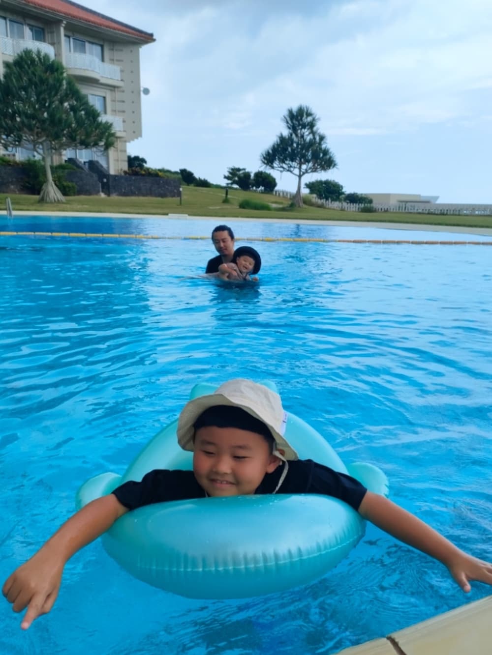 ブラウン系のサンダル、ブルー系のサンダル、ブルー系のスイムグッズを着用したキッズの夏コーディネートの4枚目の写真