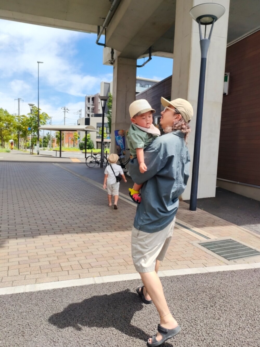 ブラック系のメッセンジャーバッグ、ホワイト系のシャツ/ブラウス、ベージュ系のパンツを着用したキッズの夏コーディネートの4枚目の写真