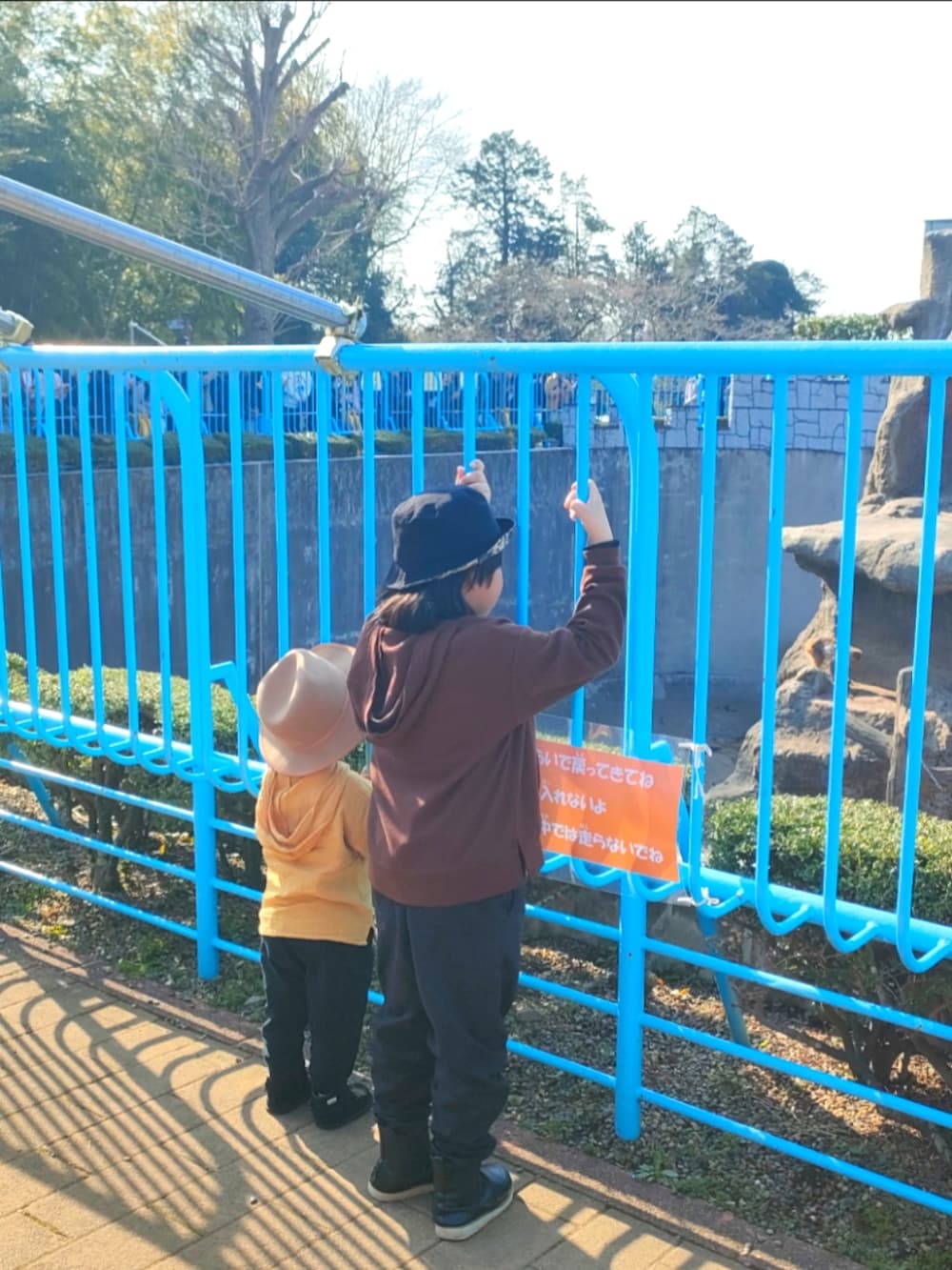 ブラウン系のパーカー、ブラック系のパンツ、ブラック系のブーツを着用したキッズの春コーディネートの2枚目の写真