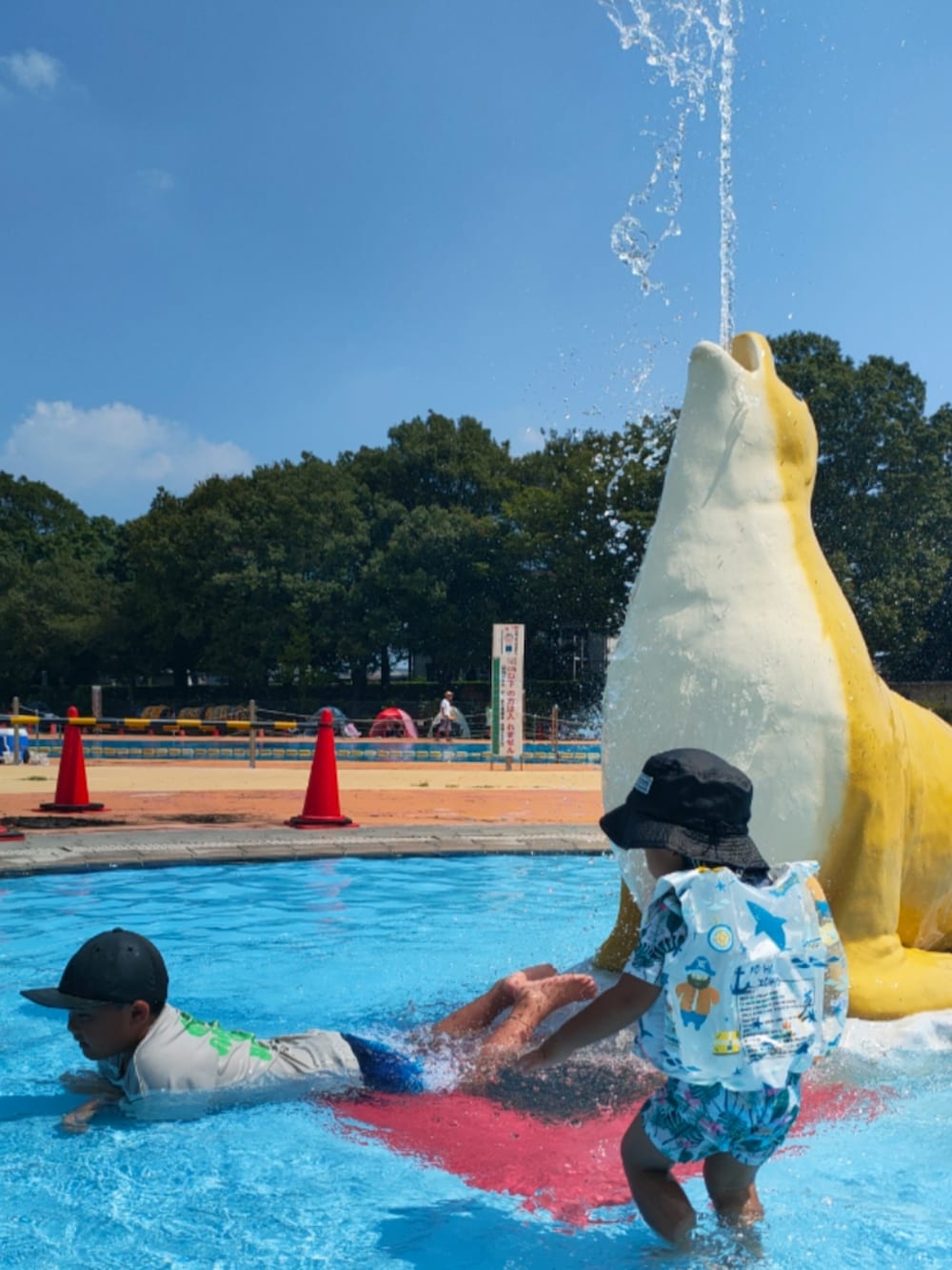 グレー系のTシャツ/カットソー、ブラック系のハット、ホワイト系のスイムグッズを着用したキッズの秋コーディネートの4枚目の写真