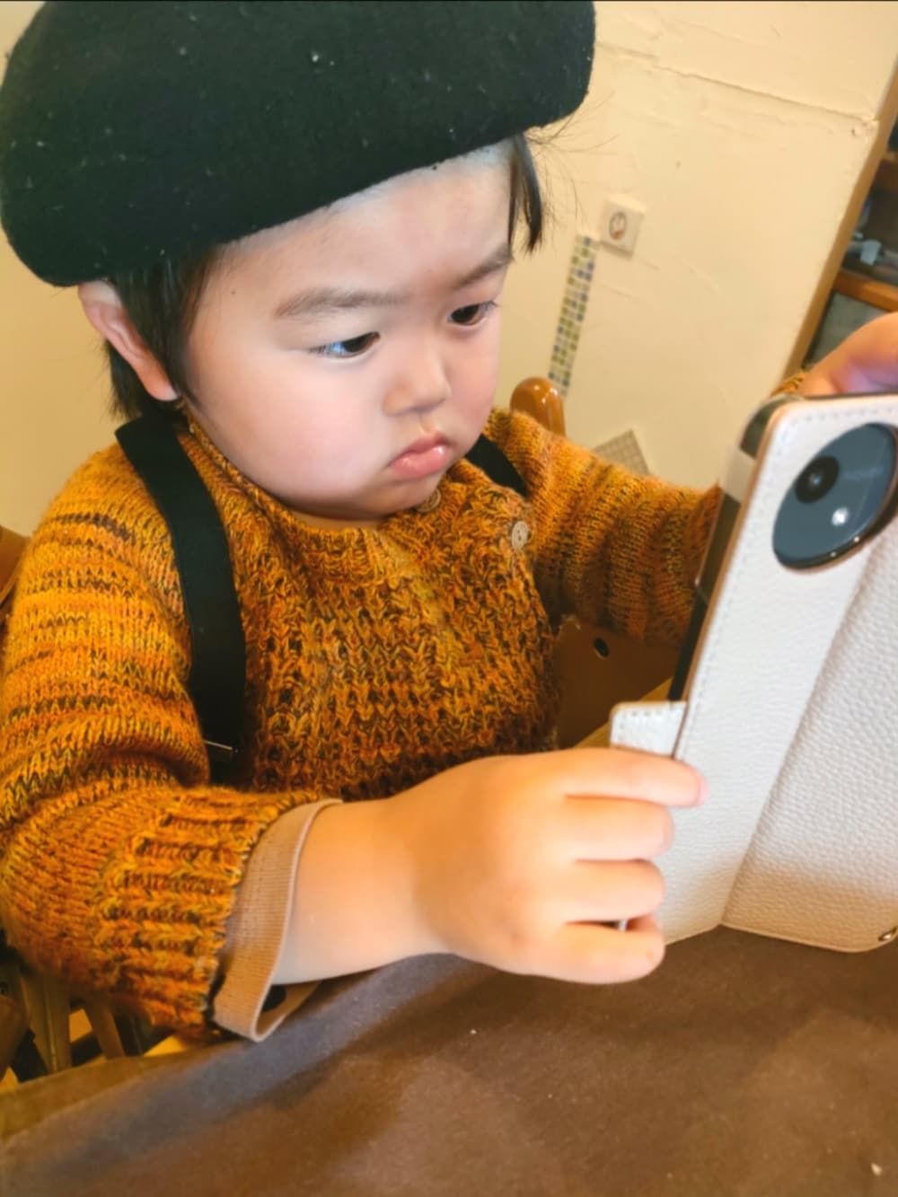 オレンジ系のニット/セーター、ブラック系のパンツ、ブラック系のレインシューズを着用したキッズの春コーディネートの2枚目の写真