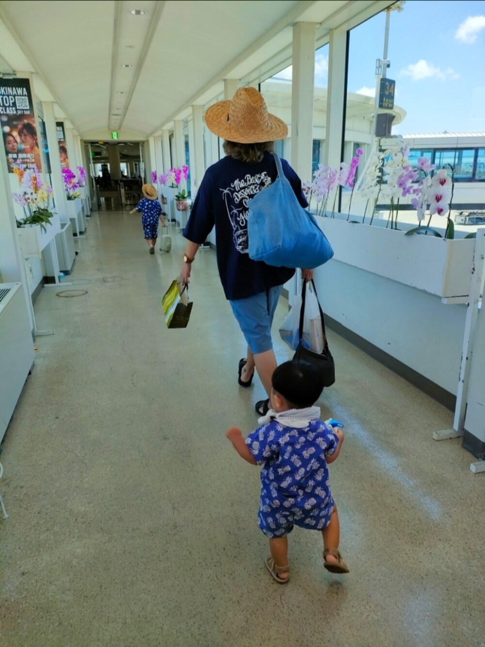 ブルー系のシャツ/ブラウス、ブルー系のその他パンツ、ベージュ系のスーツケース/キャリーバッグを着用したキッズの夏コーディネートの3枚目の写真