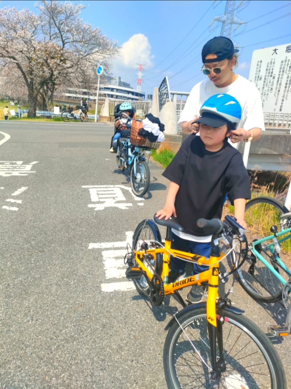 ブルー系のサロペット/オーバーオール、ホワイト系のスニーカー、ブルー系のデニムパンツを着用したキッズの春コーディネートの2枚目の写真