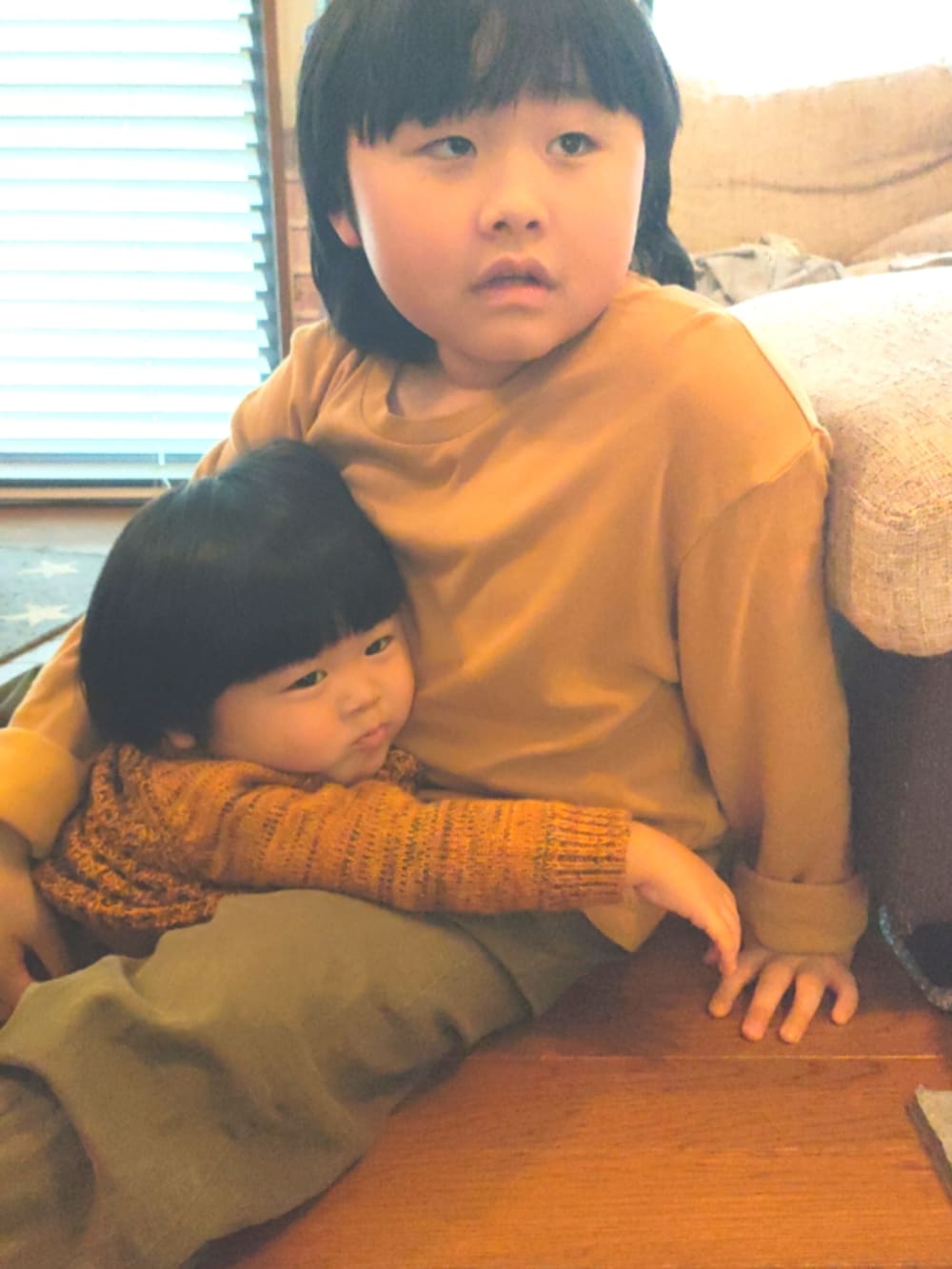 オレンジ系のニット/セーター、ブラック系のパンツ、ブラック系のレインシューズを着用したキッズの春コーディネートの4枚目の写真