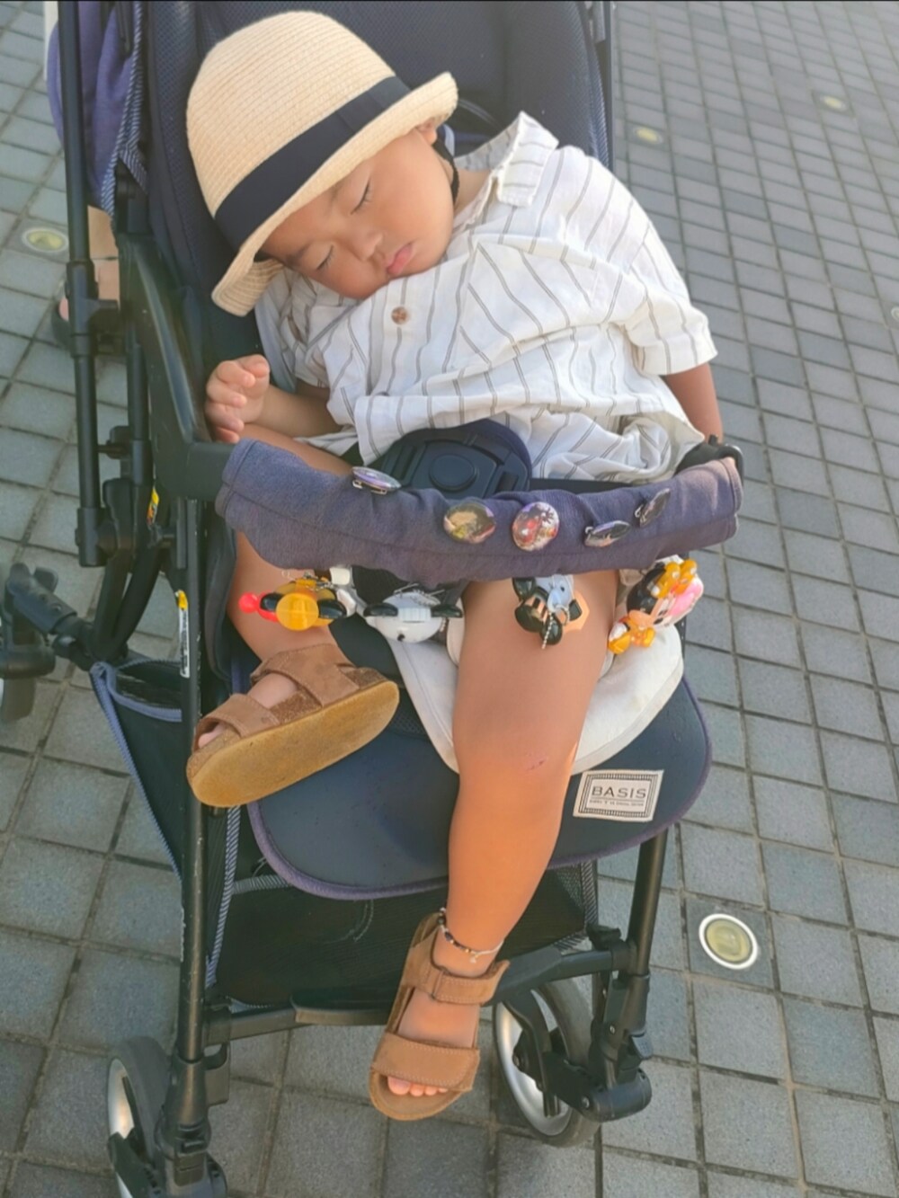 ホワイト系のセットアップ、ブラウン系のサンダル、ホワイト系のスーツケース/キャリーバッグを着用したキッズの夏コーディネートの4枚目の写真