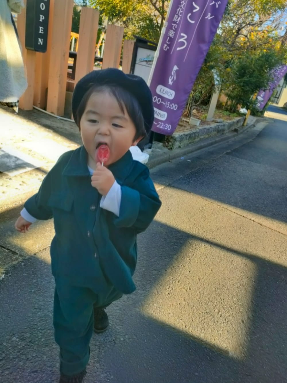 グリーン系のセットアップ、ブラック系のブーツ、ブラック系のハンチング/ベレー帽を着用したキッズの冬コーディネートの4枚目の写真