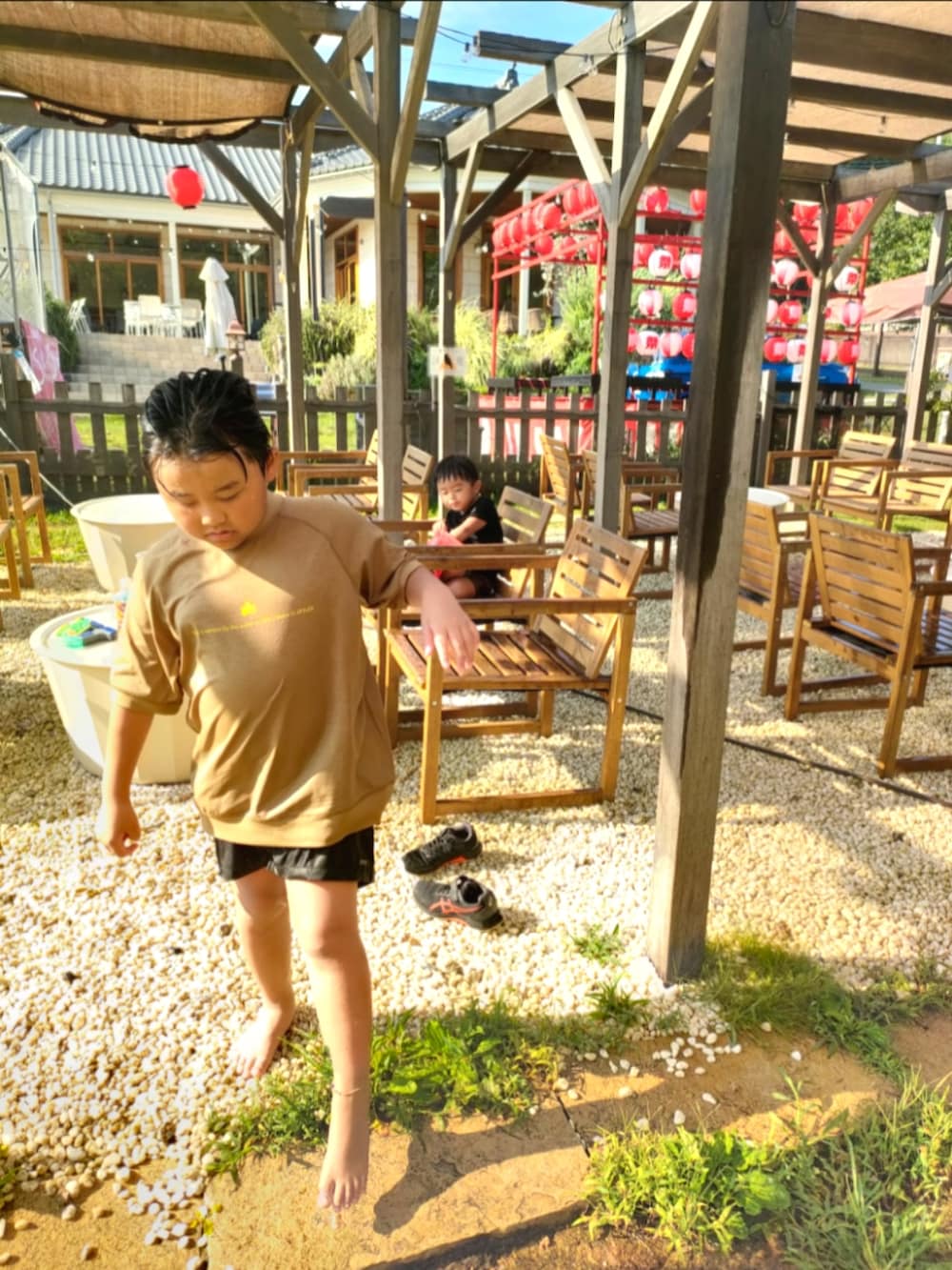 ブラック系のTシャツ/カットソー、ブラウン系の水着、ベージュ系のラッシュガードを着用したキッズの夏コーディネートの3枚目の写真